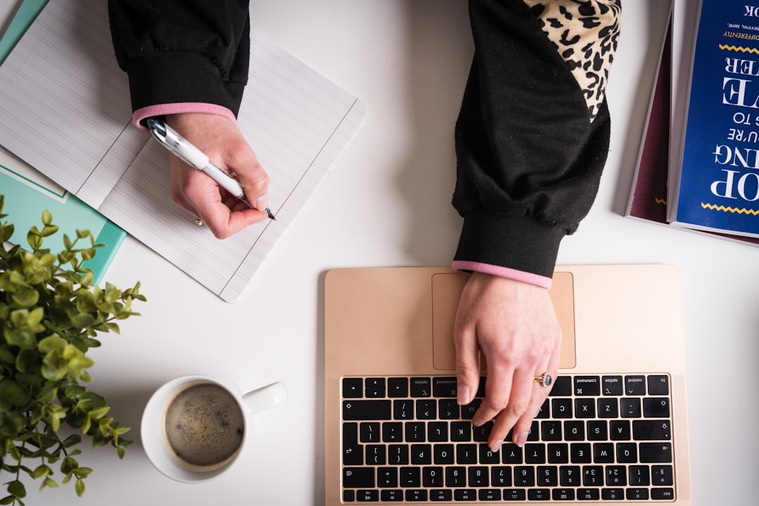 Person writing digital content on laptop