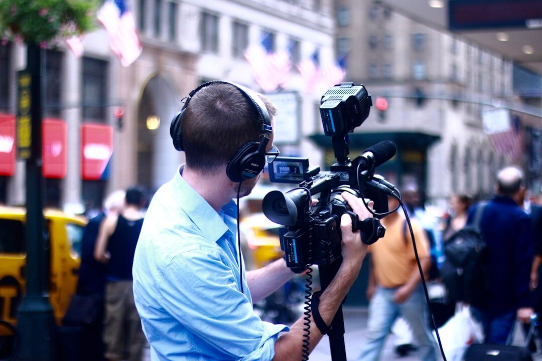 Video journalist filming with professional camera